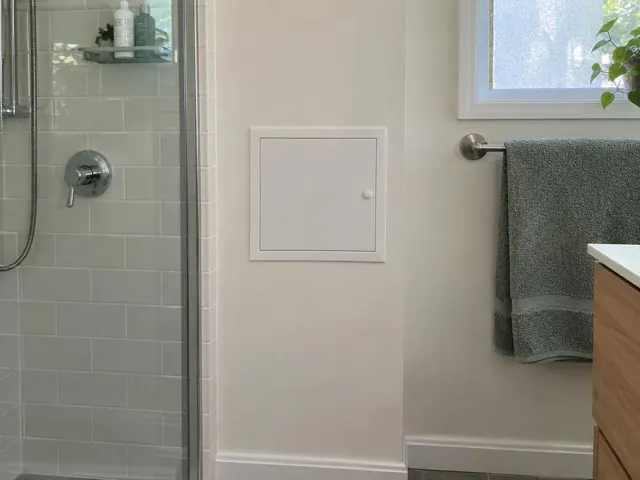 Small access panel on a bathroom wall beside a shower and towel rail in Pymble